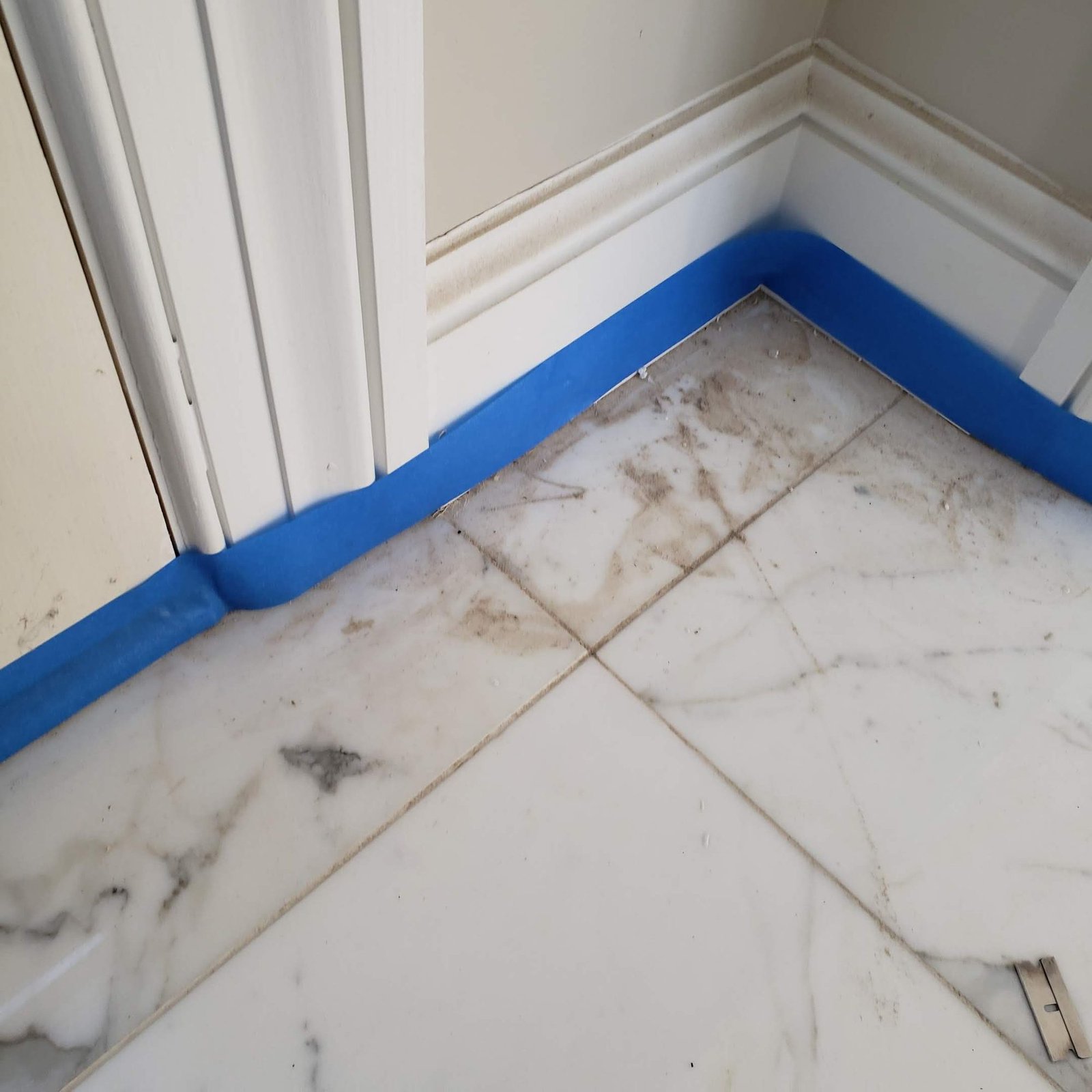Veined white marble tile marked and soiled before cleaning and polishing