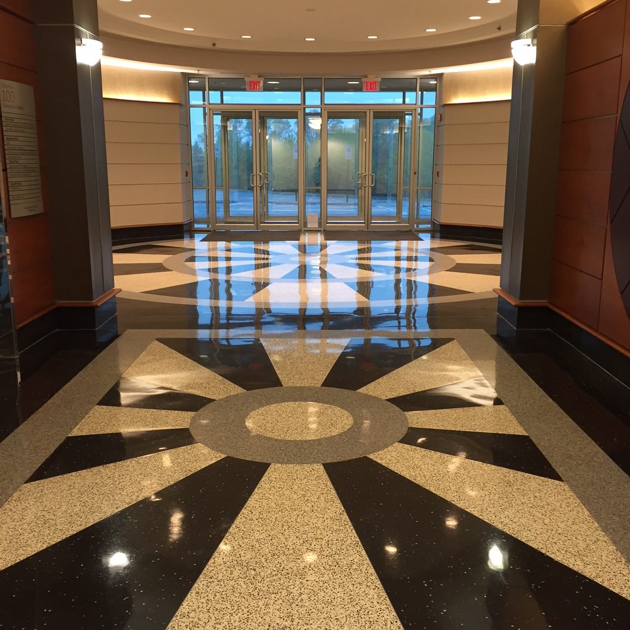 Polished terrazzo lobby floor with a bold black-and-cream starburst medallion