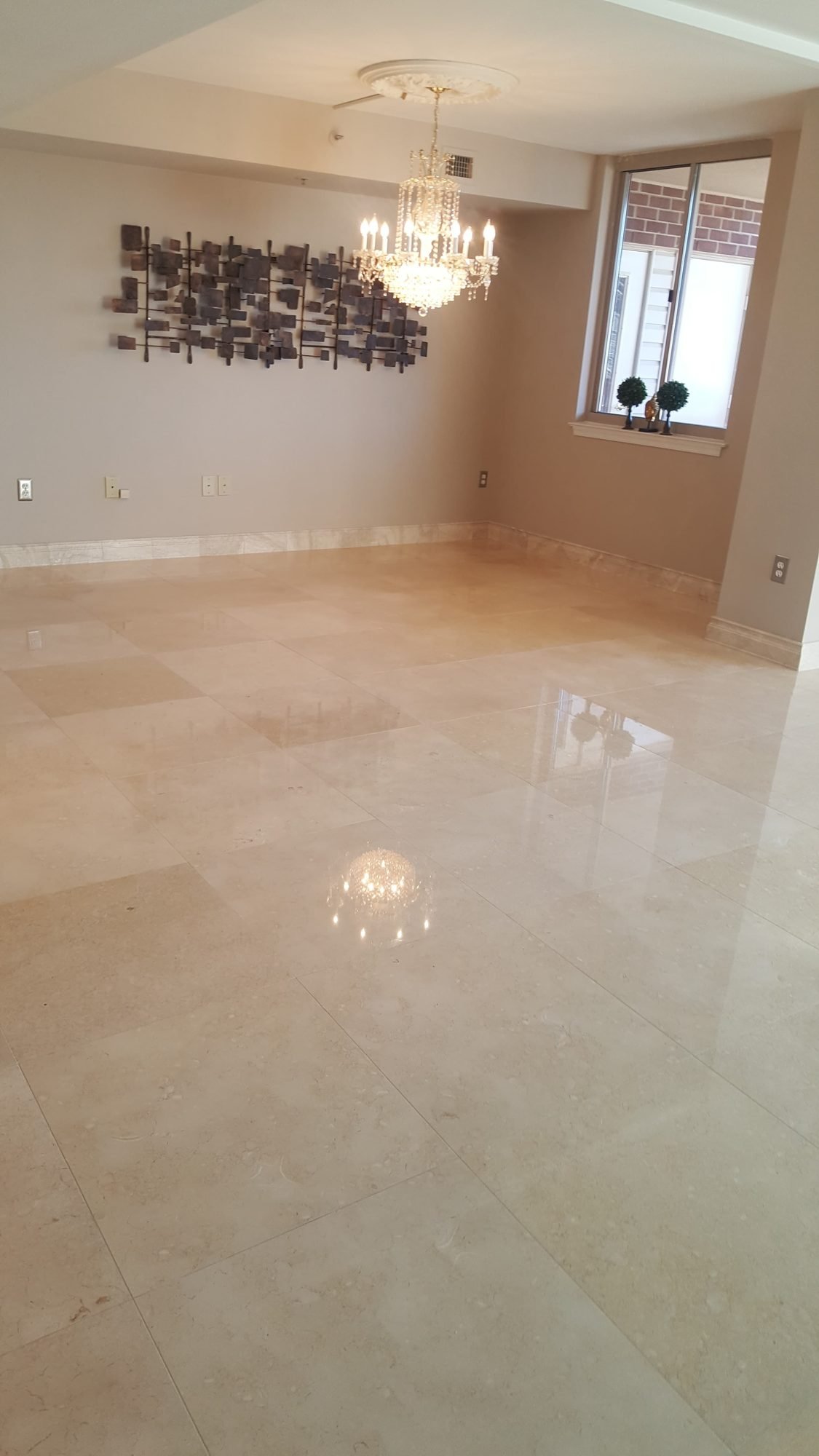 Reflective polished marble floor in an elegant furnished room with a chandelier