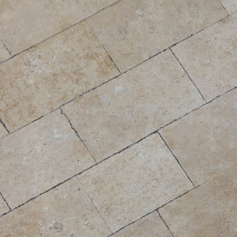 A limestone tile floor surface.