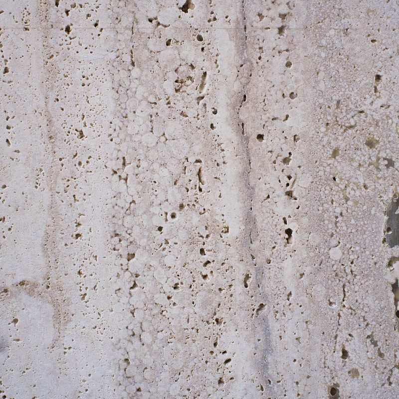 Close-up of a porous travertine stone surface.
